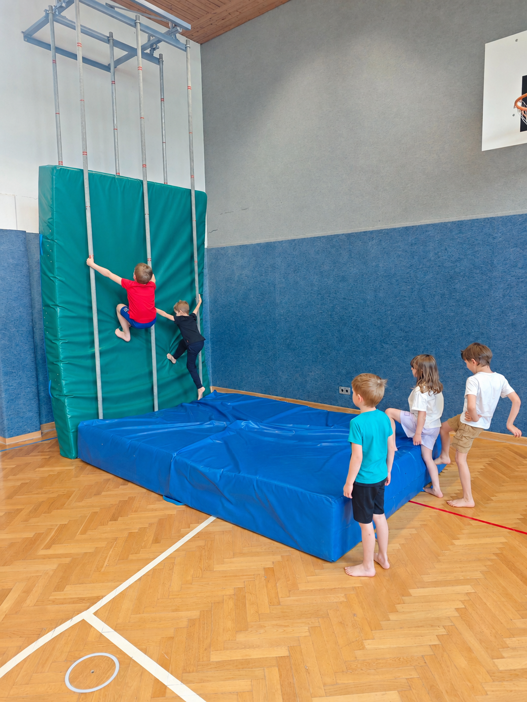 Kinder beim Klettern und Bewegen in einer Turnhalle